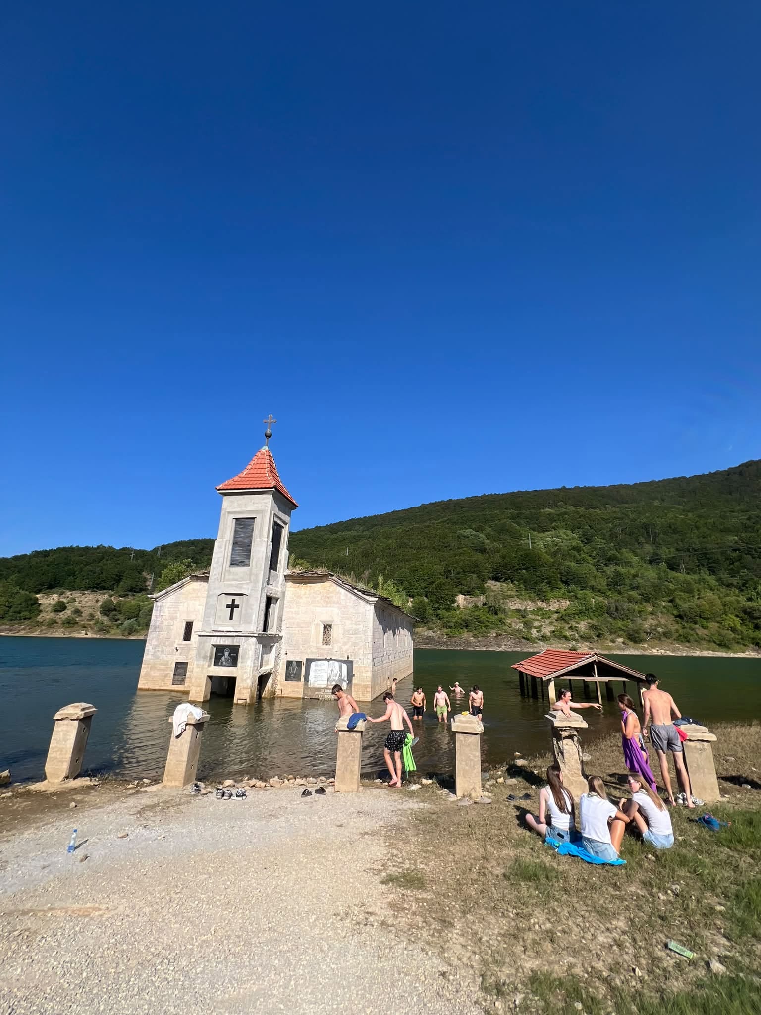 Туристи во костими за капење се качија на црквата во Мавровско езеро, низа реакции на социјалните мрежи