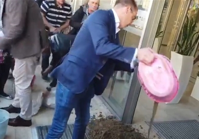 Белградските опозиционери истурија кофи со кал пред влезот во градското собрание (ВИДЕО)